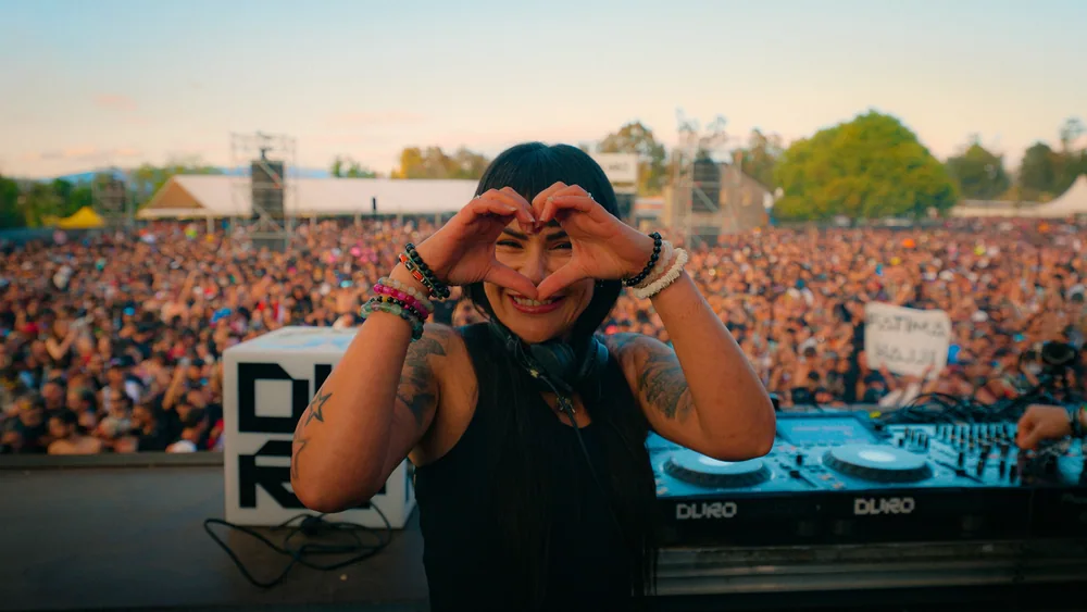 Fátima smiling and making a heart with her hands in front of the Duro crowd