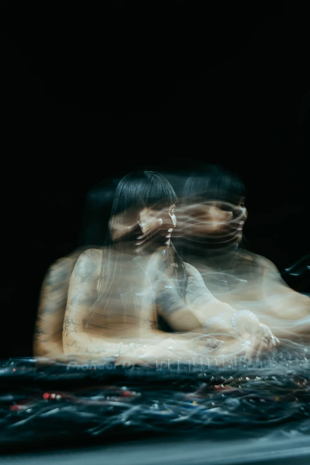 A long-exposure photograph tracing Fátima’s movement behind the decks